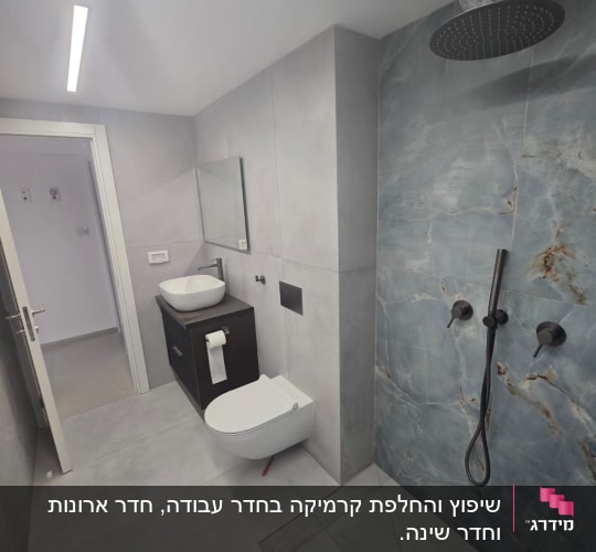 חדר אמבטיה עם מקלחון, כיור ואסלה תלויה